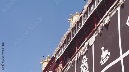 Low angle view of Tibet temple with blue sky background, white curtain flying in wind, crows flying by, 4k slow motion footage b roll shot, travel concept.