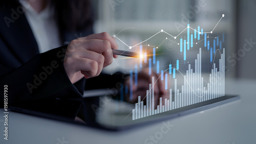 Cuadro en lienzo Businesswoman interacts with financial data on a digital tablet, showcasing a modern approach to analyzing market trends and investment strategies through innovative technology