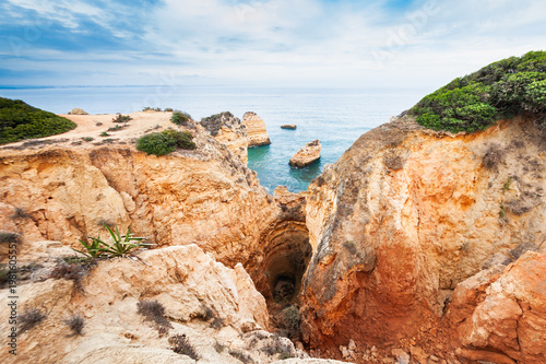 Yellow sandstone rocks and turquoise water on the coast of Atlantic ocean in Algarve, Portugal.