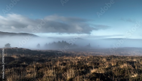 Misty Mountains and Foggy Moorland Landscape Under Cloudy Sky.