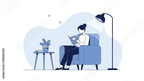 Peaceful young woman relaxing in a cozy blue armchair while reading an interesting book under the warm light of a lamp.
