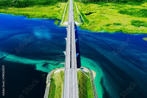 Aerial View of a Modern Bridge Spanning Over a Serene Body of Water Surrounded by Lush Greenery