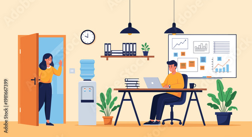 Busy office worker focuses on his laptop at a desk while a female colleague enters the room to start her workday or have a discussion.