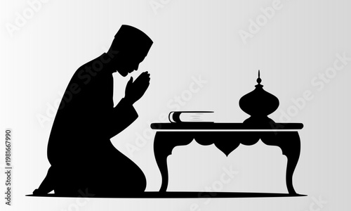  Black silhouette of Muslim man in cap kneeling in prayer with hands raised beside decorative table with Quran and ornamental vase on white background
