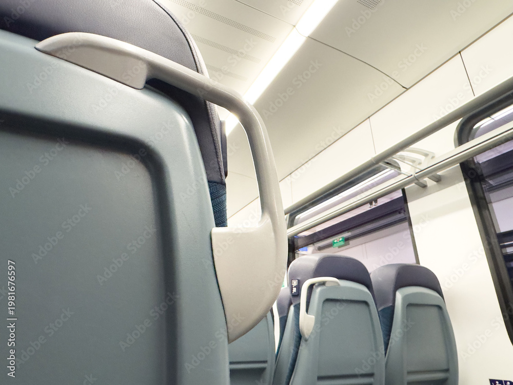 Obraz premium Empty modern train interior with blue seats and overhead storage