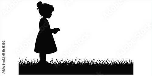Silhouette of a young girl with hair bun holding small objects in grass on white child field