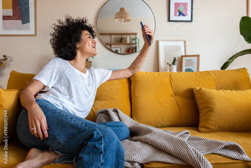 Happy woman recording smartphone video at home