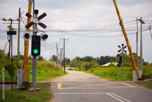 Valokuva An empty railway level crossing with green signal and open barriers