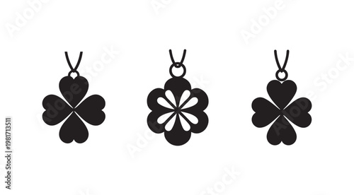Black silhouettes of heartshaped fourleaf clover pendants with different designs on a white background  heart leaf shapes and flower cutouts