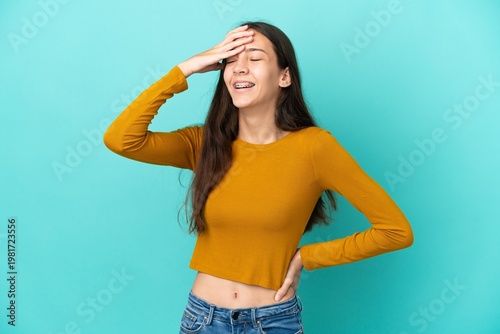 Young French woman isolated on blue background smiling a lot