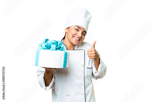 Woman pastry chef with a big cake with thumbs up because something good has happened