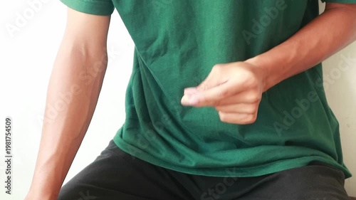 Close-up of a person sitting and fingering against a plain white background