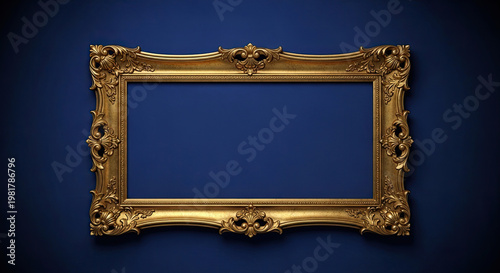 A gold ornate picture frame on a dark blue background with empty space for a photo