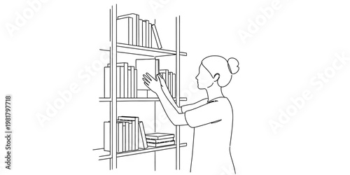 A woman with her hair in a bun is carefully selecting a book from a shelf in a quiet library room