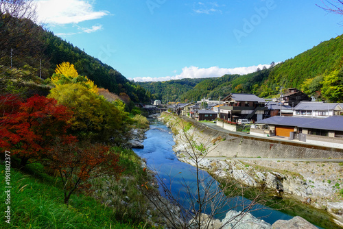 Sunny mountain village with river and autumn foliage along Shikoku Henro route Japan
