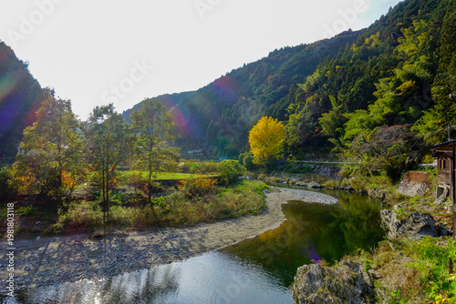 Sunlit river bend with autumn trees and rural landscape along Shikoku Henro Japan