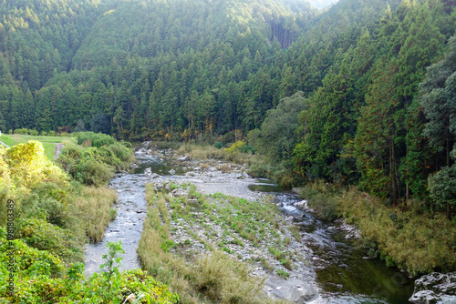 Shallow forest river with rocky banks along Shikoku Henro countryside in Japan