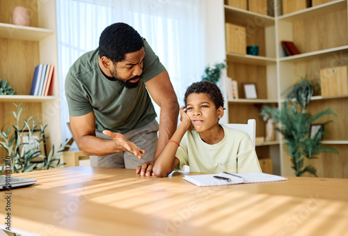Foto Father and son doing homework fighting and arguing over learning at home