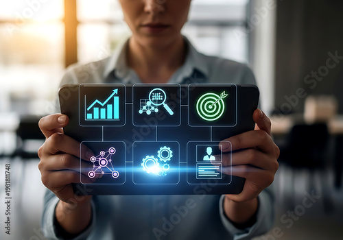 A business professional holding a tablet device displaying various digital icons representing data analysis and strategy planning