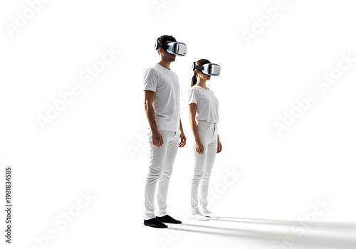 A man and a woman standing in white clothing while wearing virtual reality headsets against a plain white background studio
