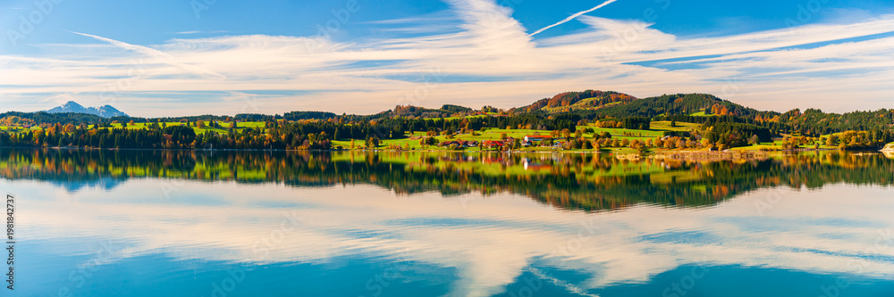 Fototapeta premium Panorama vom Forggensee im Allgäu bei Dietringen mit symmetrischer Wasserspiegelung