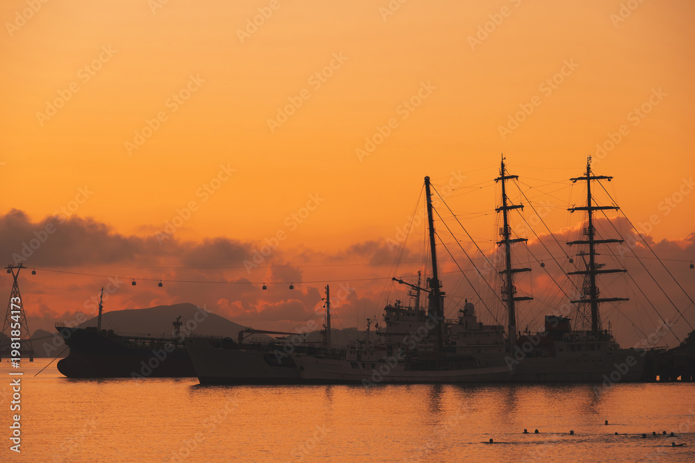 Obraz premium Silhouettes of Vietnamese warships military ships in port at sea in the morning at dawn in harbor in Nha Trang in Vietnam