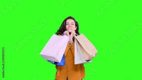 Beautiful young female shopper smiling happy with bags on the chroma key