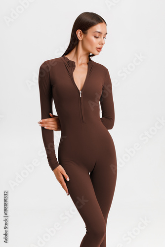 Athletic woman in jumpsuit. Fitness girl on the gray background