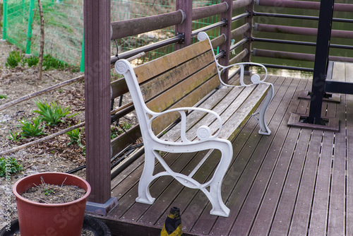 Weathered Wooden Park Bench on a Deck Overlooking a Tranquil Water Body