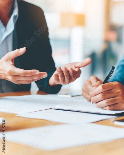Empathy communication conflict management over shoulder perspective of professional writing note during meeting no faces visible quiet workspace neutral tones soft lighting