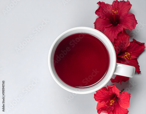 Vibrant red hibiscus tea infusion in a white cup with tropical flowers and star anise, elegant wellness and herbal concept, top view,  digital art, AI generated, copy space