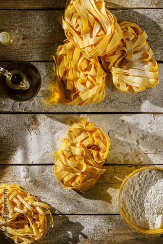 raw fettuccine on a wooden table with flour
