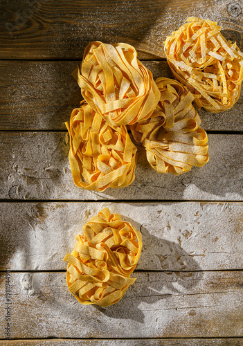 raw fettuccine on a wooden table with flour