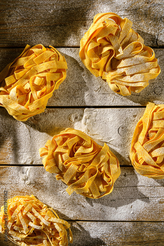 raw fettuccine on a wooden table with flour