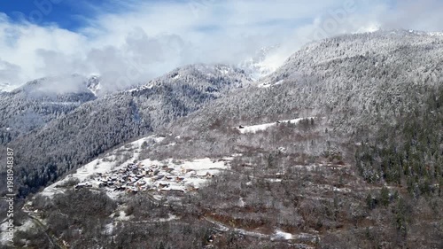 Snow covered alpine village in Tarentaise Valley with traditional houses and mountain scenery in the French Alps, Savoie, France.