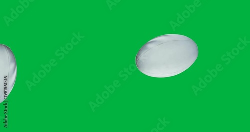 Digital animation of multiple rugby balls falling against black background