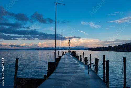 Amazing sunset seen from the pier of the city of Rorschach over Lake Constance in the Sankt Gallen region in Switzerland with an impressive rolling cloudscape full of unpredictable weather and snow sh