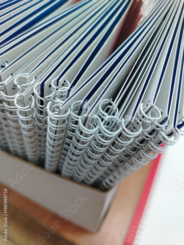 Bild auf Leinwand Stack of spiral-bound notebooks with white pages and blue covers arranged neatly