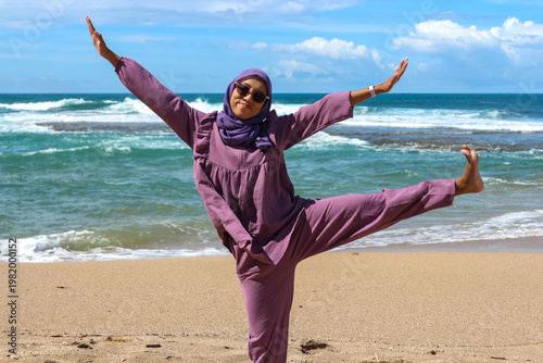 Asian Muslim woman on vacation at the beach with a happy expression