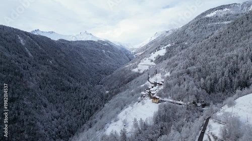 Snow covered alpine village in Tarentaise Valley with traditional houses and mountain scenery in the French Alps, Savoie, France.