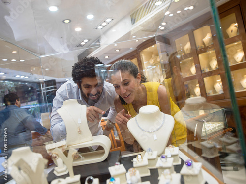 Foto Couple shopping for jewelry and admiring rings and necklaces in a luxury store d