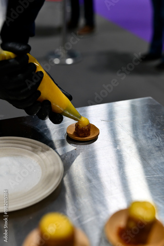 repostero profesional echando crema pastelera en un bocado dulce