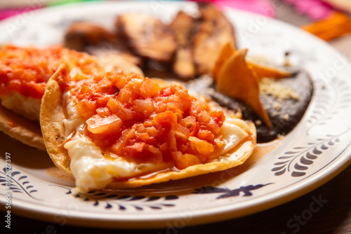 Traditional Mexican breakfast with tostadas, fried plantains, and black beans