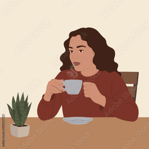 A woman sits at a table sipping coffee from a cup with a plant nearby
