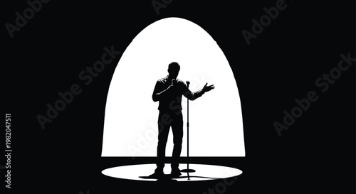 A silhouetted figure of a man standing with a microphone in a bright illuminated oval spotlight