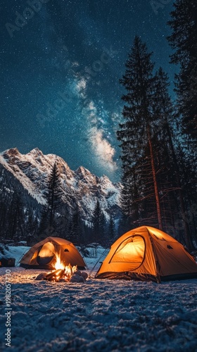 Tents by the campfire under a starry sky in the mountains evoke a sense of adventure, creating the perfect atmosphere for winter camping.