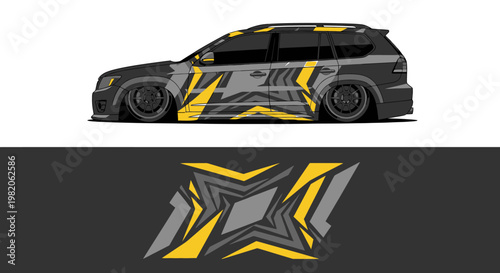 Sleek black and yellow race car with bold graphic livery and angular design on a dark track.