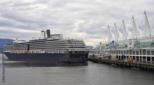 Modern luxury cruiseship cruise ship liner Oosterdam returning to Vancouver, BC Canada from Alaska cruise during early morning grey misty rainy foggy day silhouette harbor landscape marine traffic