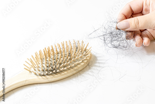 Φωτογραφία Close-up of wooden hairbrush filled with fallen hair in female hand, concept of hair loss, alopecia, stress, hormonal imbalance, unhealthy scalp and excessive shedding