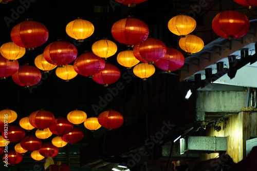 Red and yellow Chinese lanterns hanging over Temple Street Night Market at night, Yau Ma Tei, Kowloon, Hong Kong